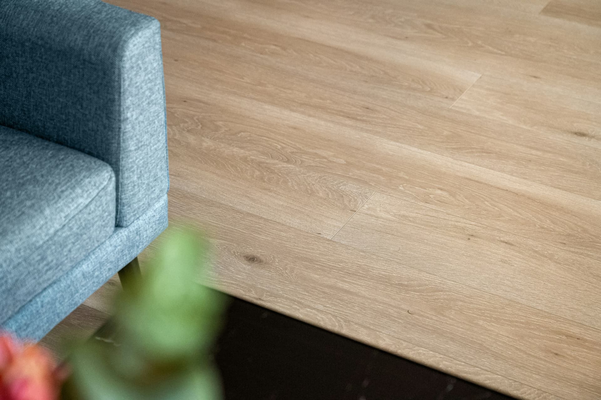 Natural oak-look luxury vinyl planks beside a linen sofa